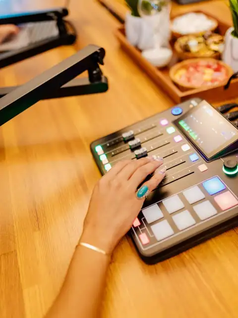 Host mixing a live podcast on the RØDECaster console